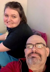 Picture of man with glasses next to a young woman. 